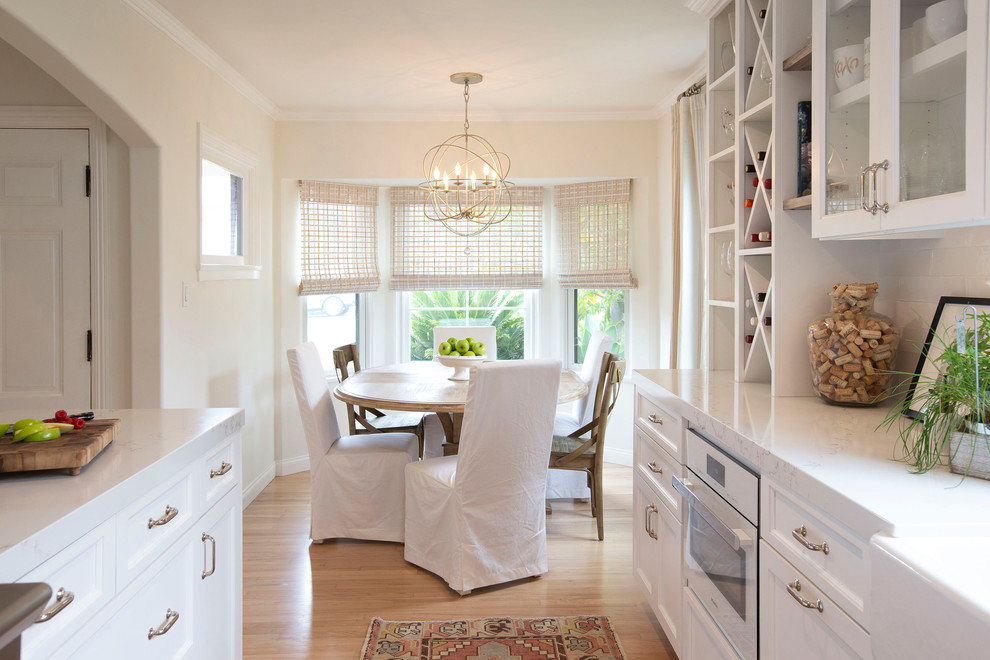 Classic kitchen/dining room in San Diego with beige walls, light hardwood flooring and beige floors.