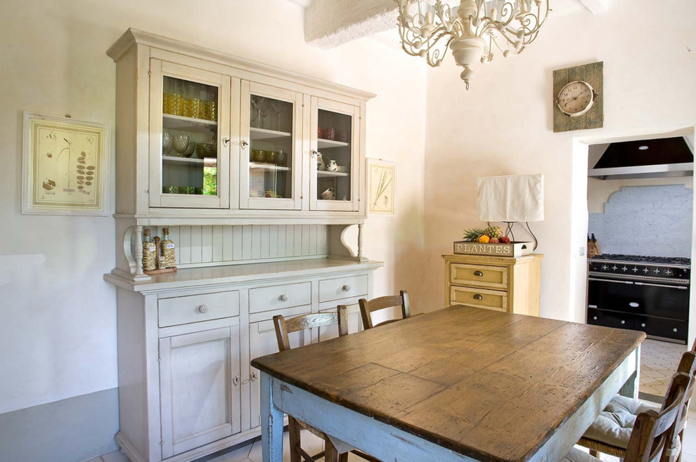 Foto di una sala da pranzo aperta verso il soggiorno country con pareti bianche