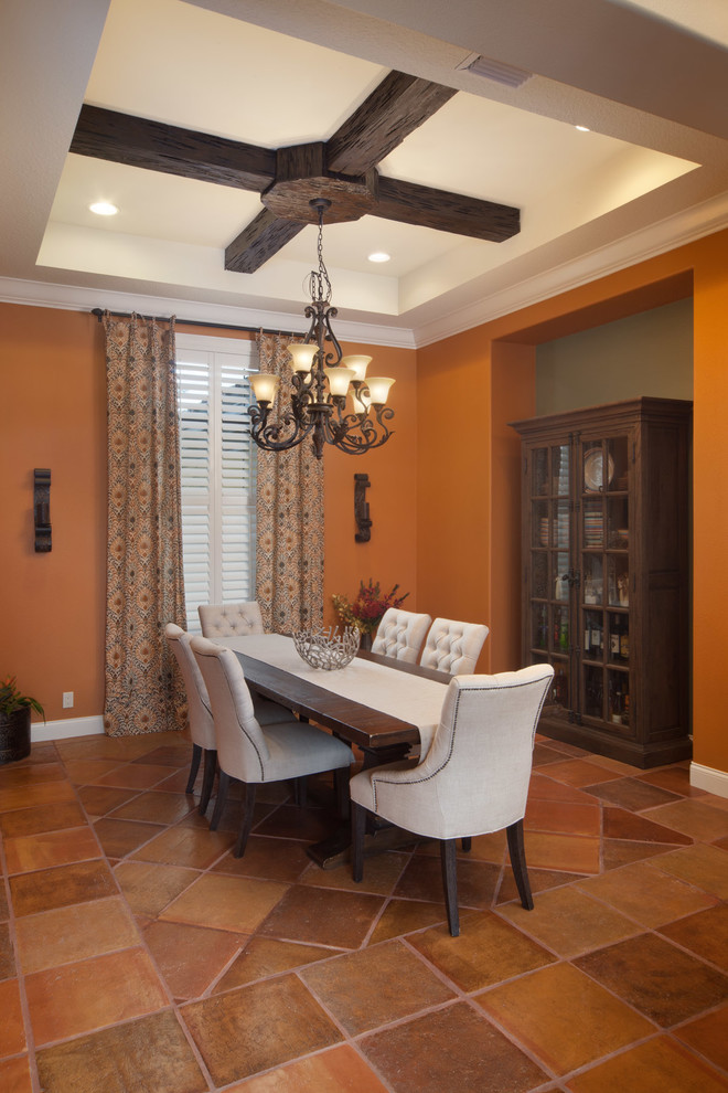 Идея дизайна: большая гостиная-столовая в средиземноморском стиле с оранжевыми стенами, полом из терракотовой плитки, стандартным камином и фасадом камина из плитки