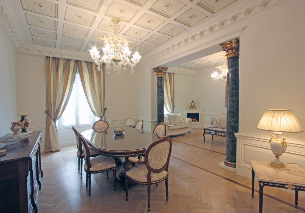 Foto di una grande sala da pranzo aperta verso il soggiorno tradizionale con pareti beige, parquet chiaro, camino ad angolo e cornice del camino in legno