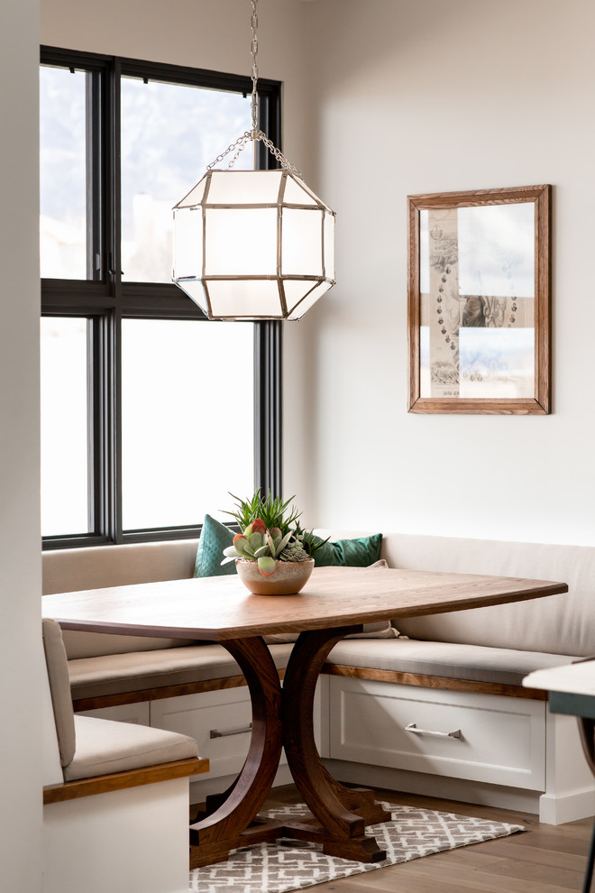 Ispirazione per una sala da pranzo aperta verso la cucina chic con pareti grigie, pavimento in legno massello medio e pavimento marrone