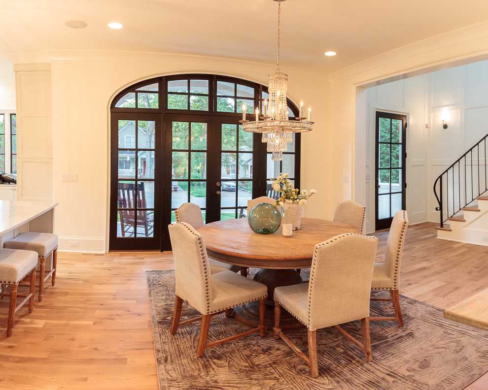 Large classic kitchen/dining room in Charlotte with white walls and light hardwood flooring.