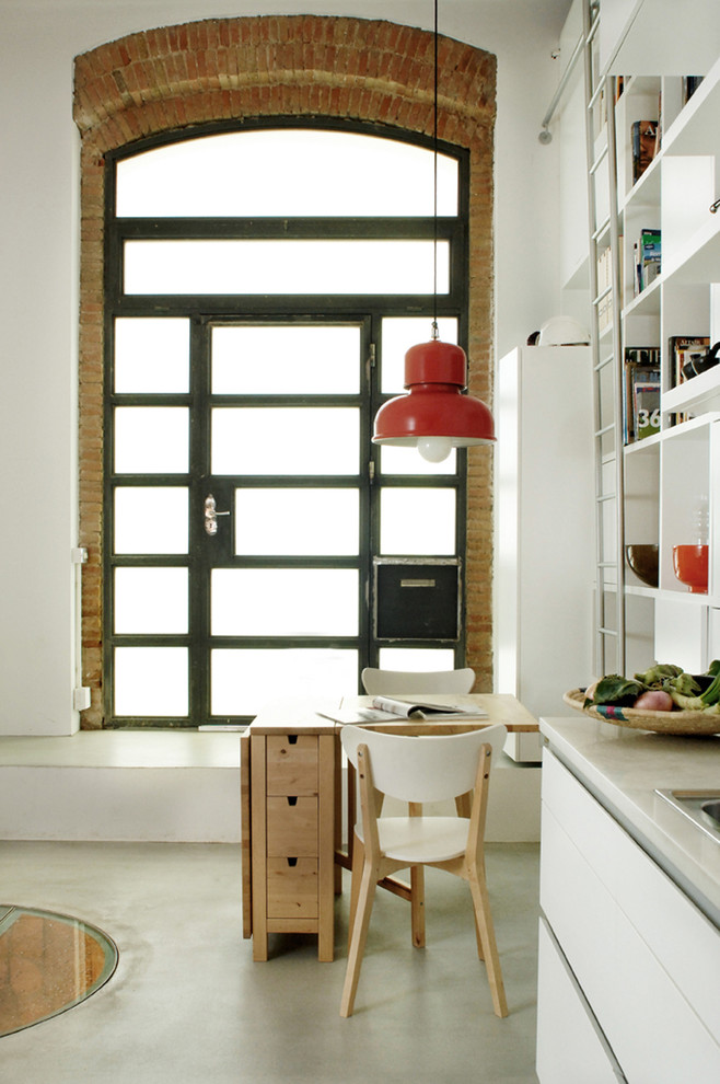 Foto de comedor de cocina industrial pequeño sin chimenea con paredes blancas y suelo de cemento