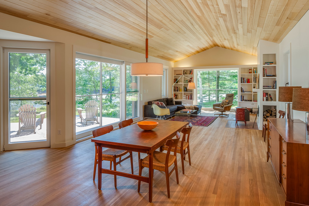 Design ideas for a rural open plan dining room in Portland Maine with medium hardwood flooring and feature lighting.