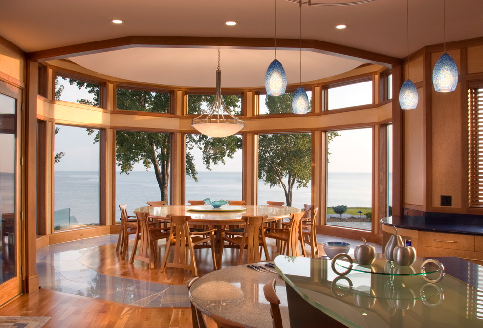 Aménagement d'une salle à manger ouverte sur la cuisine bord de mer avec un sol en bois brun.