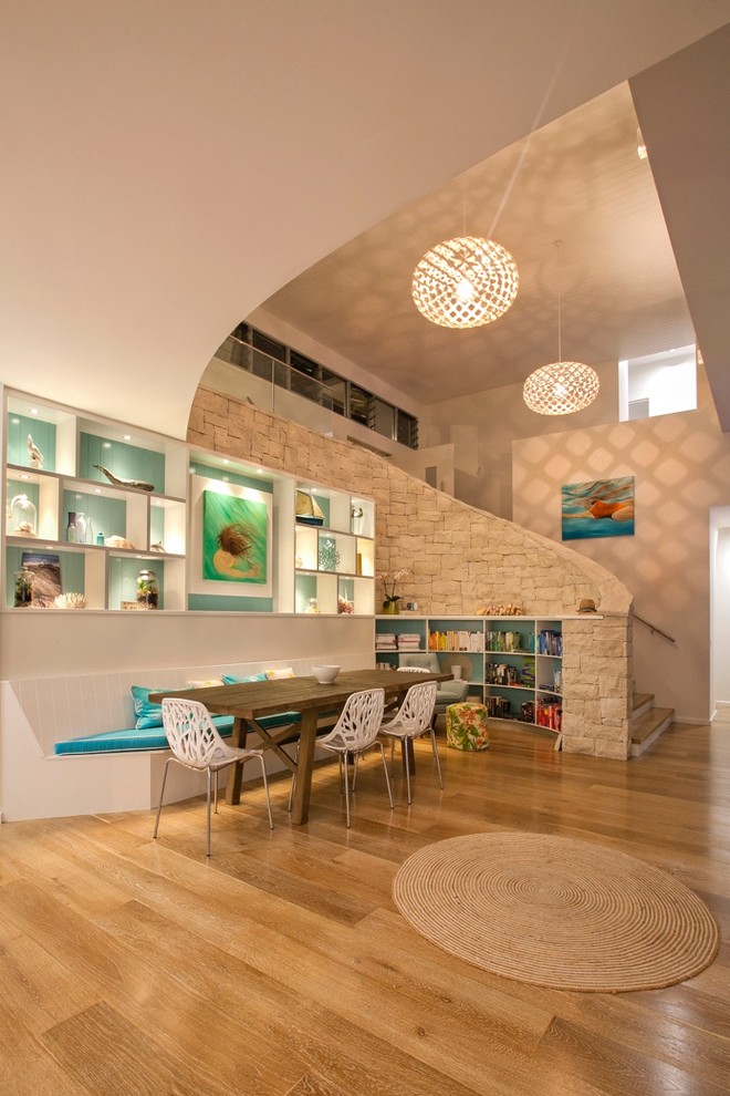 Immagine di una sala da pranzo stile marino con pareti bianche e pavimento in legno massello medio