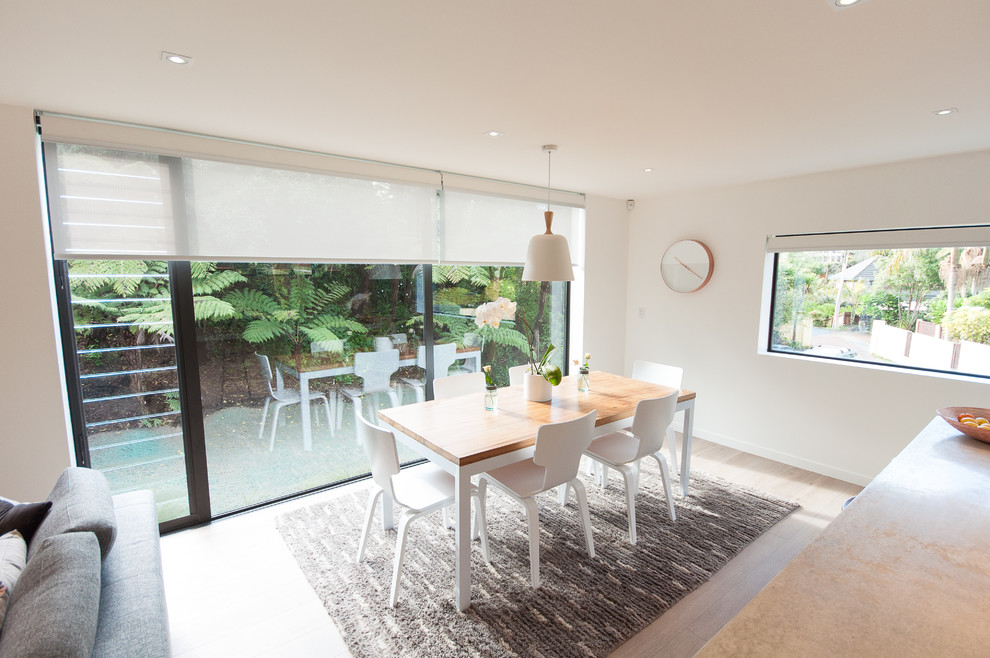 Mittelgroße Moderne Wohnküche ohne Kamin mit weißer Wandfarbe und hellem Holzboden in Auckland