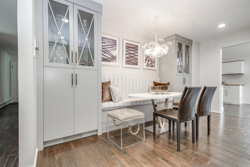 Idée de décoration pour une salle à manger ouverte sur la cuisine design de taille moyenne avec un mur blanc, parquet clair et un sol marron.