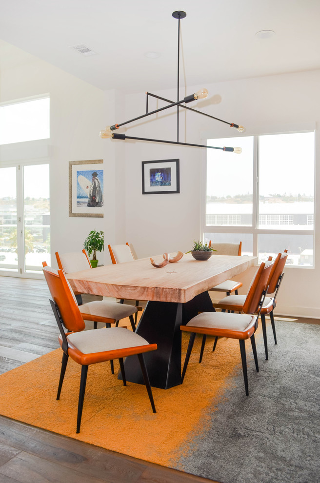 Photo of a large midcentury open plan dining room in Los Angeles with white walls, medium hardwood flooring, no fireplace and grey floors.