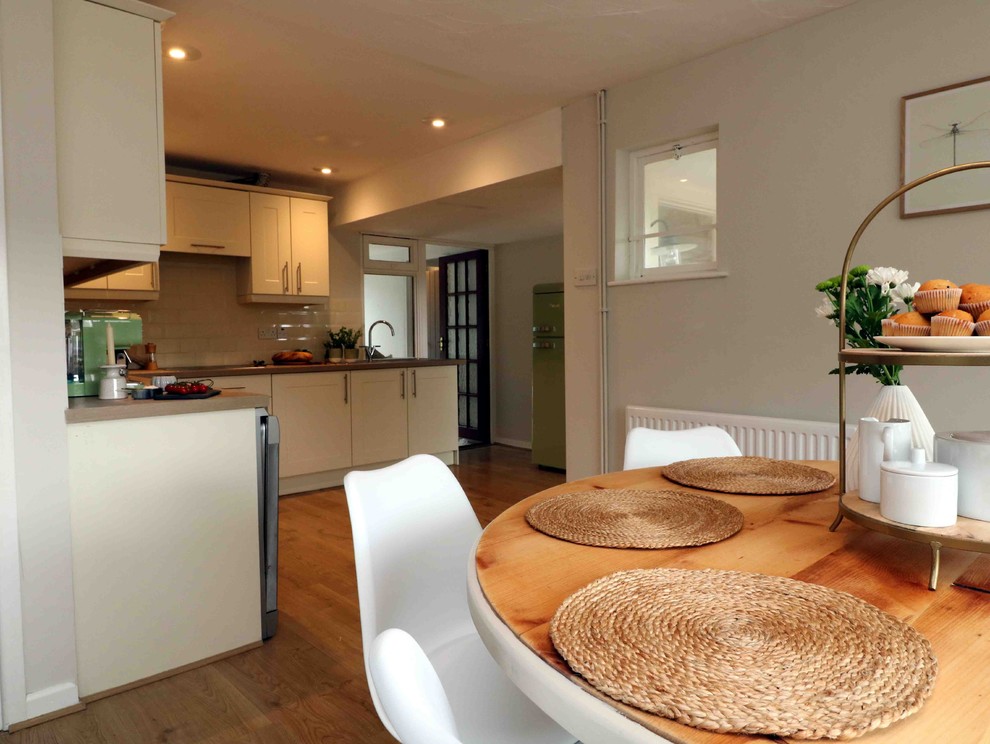 Mittelgroße Landhausstil Wohnküche ohne Kamin mit beiger Wandfarbe, hellem Holzboden und beigem Boden in Devon