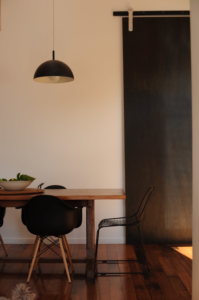 Exemple d'une petite salle à manger ouverte sur le salon tendance avec un mur blanc et un sol en bois brun.