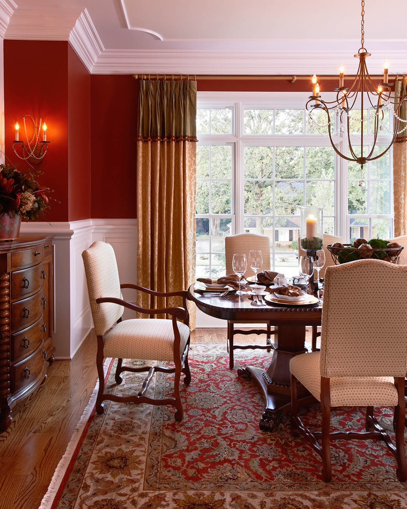 Inspiration for a classic dining room in Charlotte with red walls.