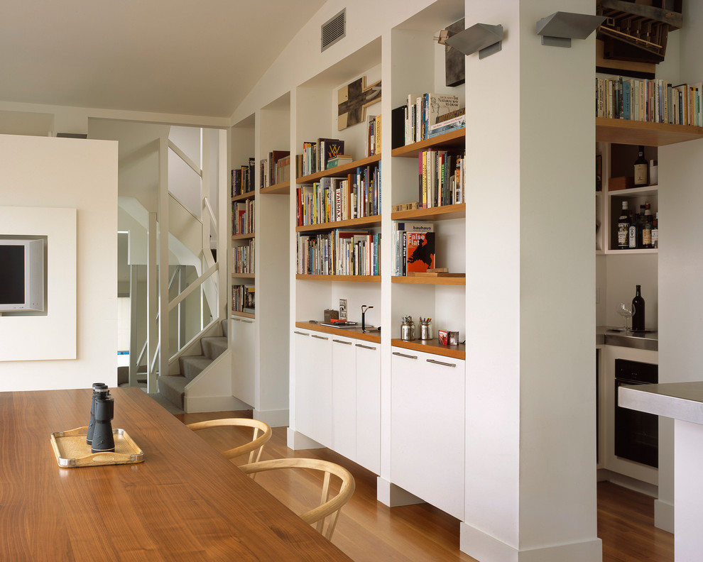 Foto di una sala da pranzo aperta verso la cucina contemporanea di medie dimensioni con pareti bianche e pavimento in legno massello medio