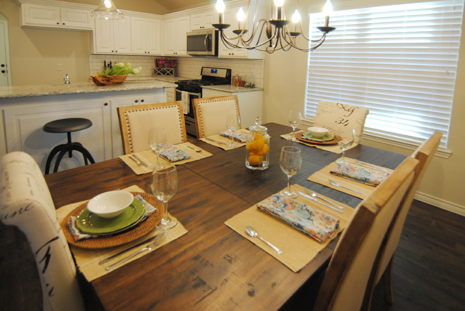 Exemple d'une salle à manger ouverte sur la cuisine chic de taille moyenne avec un mur blanc, un sol en vinyl et un sol marron.