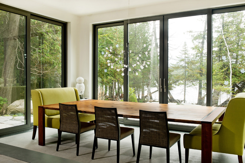 Idee per una grande sala da pranzo aperta verso il soggiorno contemporanea con pareti bianche e pavimento in cemento