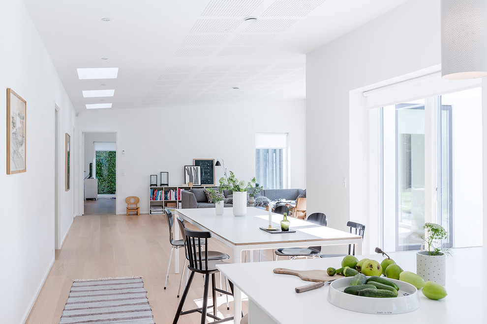 This is an example of a medium sized scandi dining room in Aarhus with white walls and beige floors.
