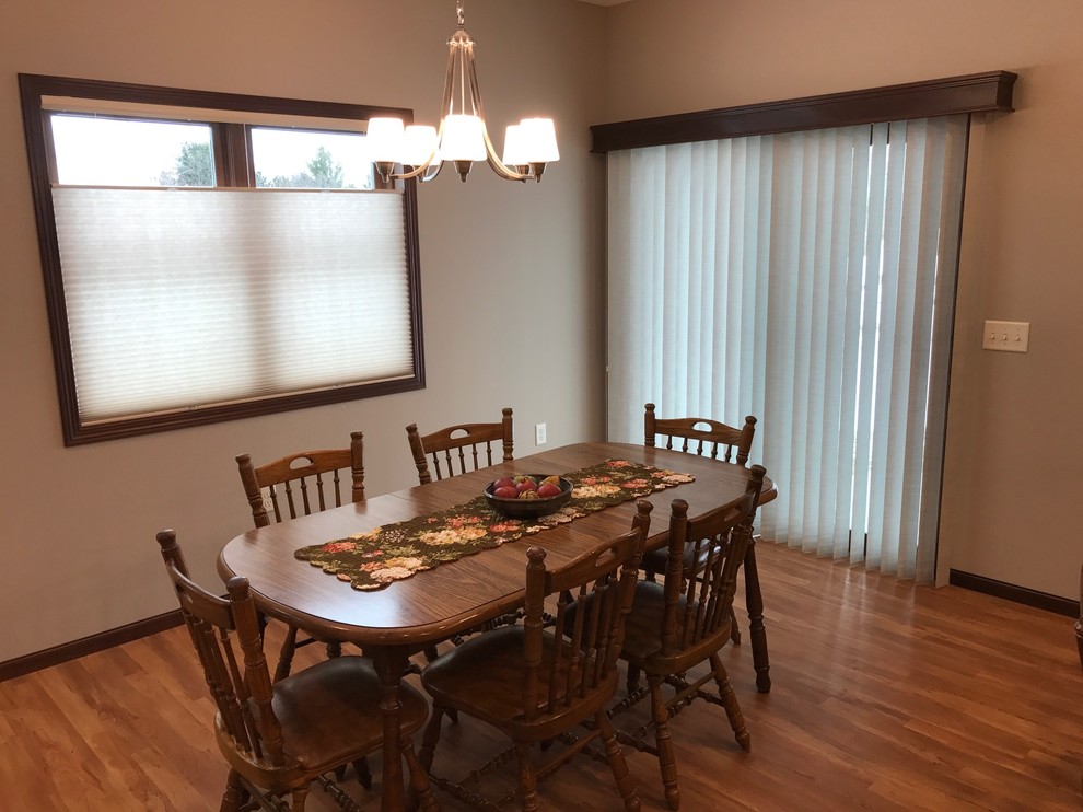 Immagine di una sala da pranzo aperta verso il soggiorno tradizionale di medie dimensioni con pareti beige, pavimento in legno massello medio, nessun camino e pavimento beige