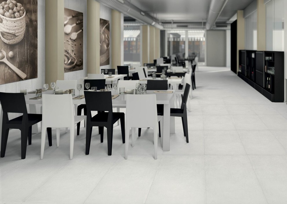 Immagine di una sala da pranzo industriale con pavimento in gres porcellanato