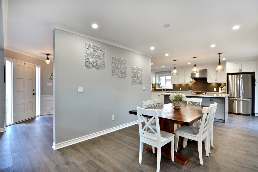 Foto di una sala da pranzo aperta verso la cucina minimalista di medie dimensioni con pareti grigie, pavimento in legno massello medio e camino classico