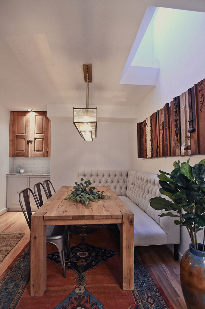 Foto di una piccola sala da pranzo aperta verso la cucina boho chic con pareti bianche e parquet chiaro