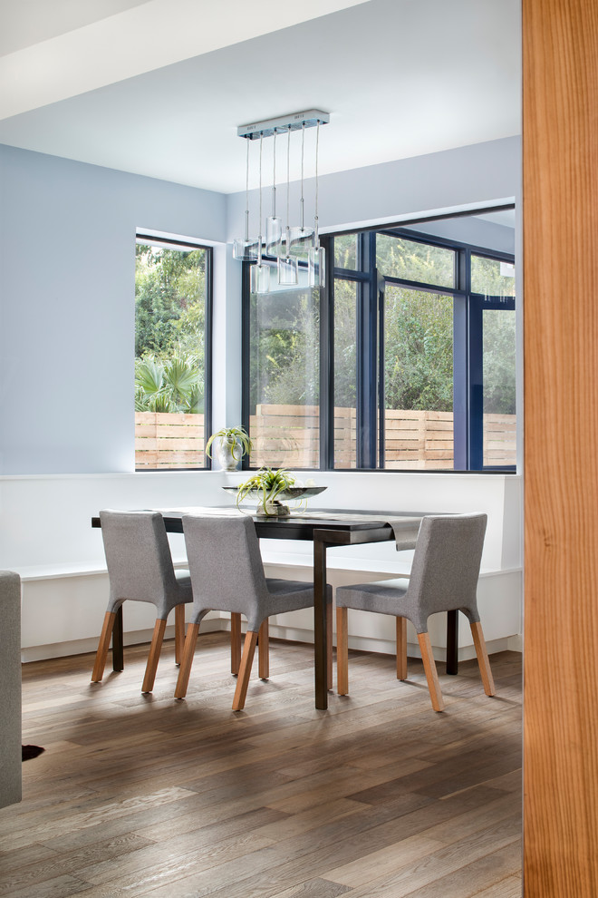 Ispirazione per una grande sala da pranzo aperta verso la cucina minimal con pareti blu, parquet chiaro, nessun camino e pavimento bianco