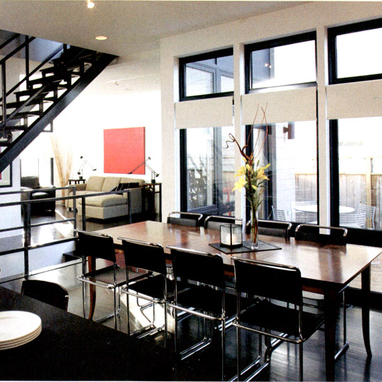 Пример оригинального дизайна: большая кухня-столовая в современном стиле с белыми стенами, темным паркетным полом и черным полом без камина