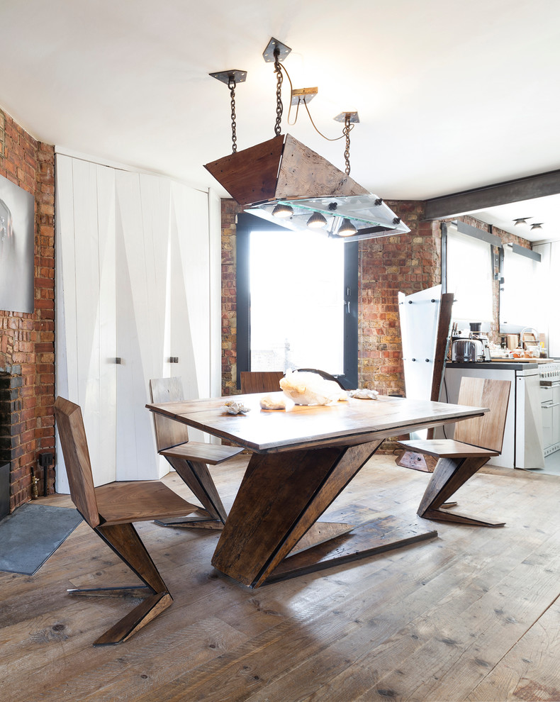 Ispirazione per una piccola sala da pranzo aperta verso la cucina industriale con pavimento in legno massello medio