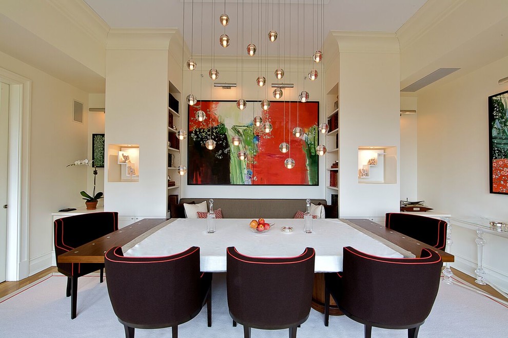 Contemporary dining room in New York with white walls and light hardwood flooring.