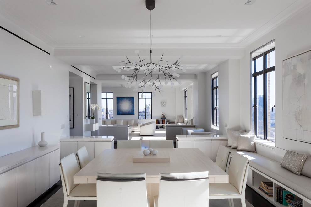 Aménagement d'une salle à manger ouverte sur le salon contemporaine avec un mur blanc et parquet foncé.