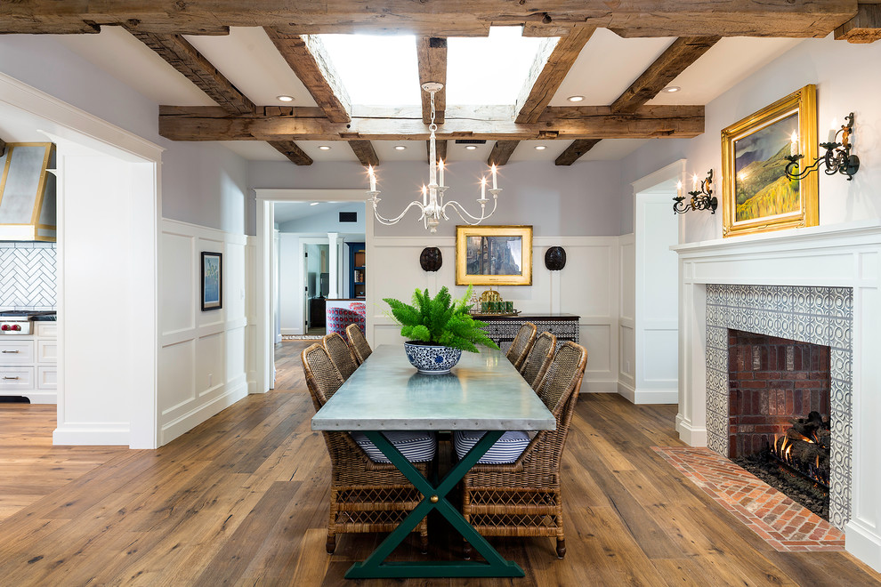 Exemple d'une salle à manger nature fermée avec un mur multicolore, un sol en bois brun, une cheminée standard, un manteau de cheminée en carrelage et un sol marron.