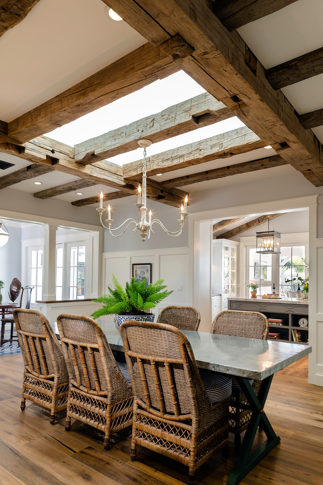 Immagine di una sala da pranzo aperta verso il soggiorno country con pareti blu, pavimento in legno massello medio e pavimento marrone