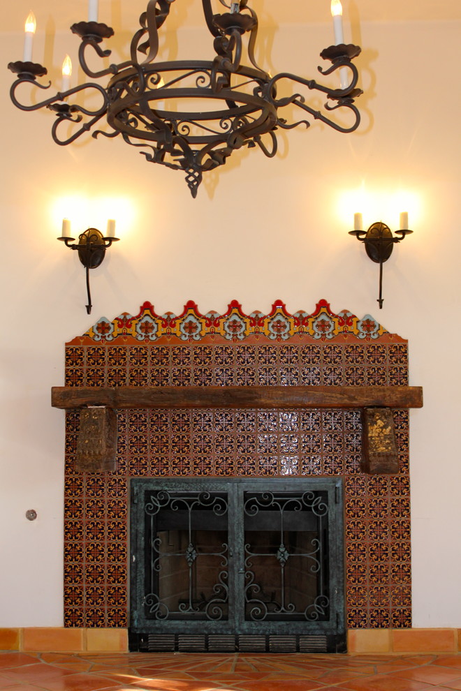 Offenes, Kleines Mediterranes Esszimmer mit weißer Wandfarbe, Terrakottaboden, Kamin und gefliester Kaminumrandung in San Diego