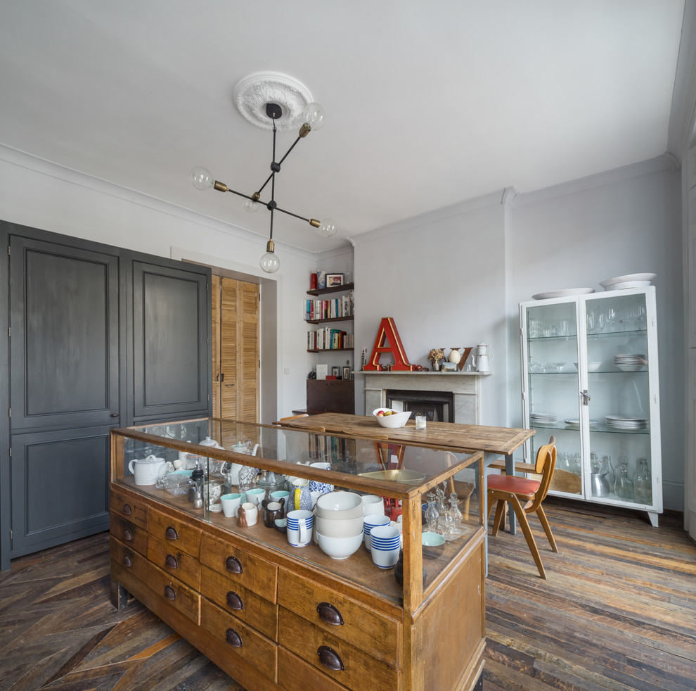 Idées déco pour une salle à manger ouverte sur la cuisine classique avec parquet foncé, un mur gris et une cheminée standard.