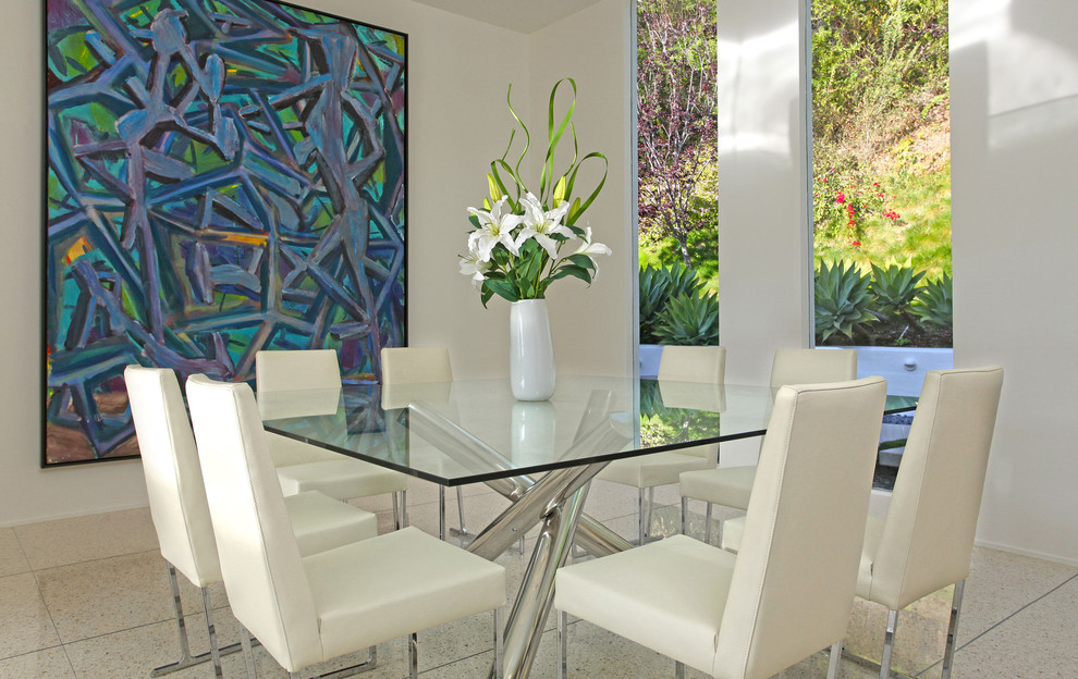This is an example of a midcentury dining room in Los Angeles with white walls.