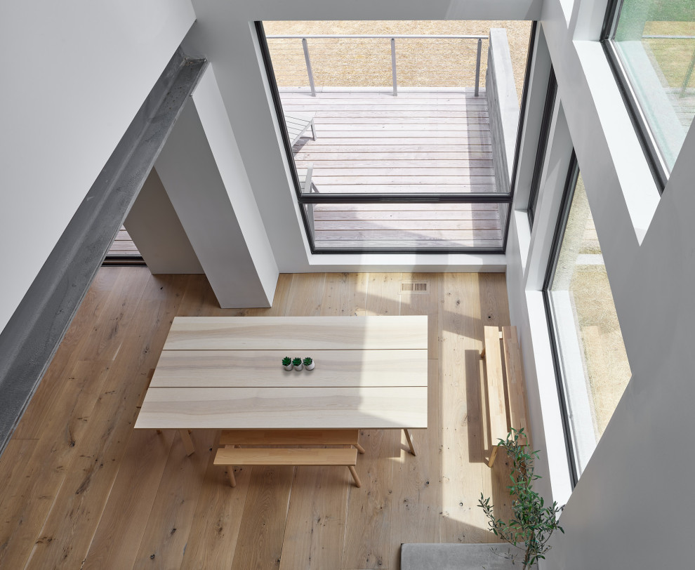 Esempio di una sala da pranzo contemporanea con pavimento in legno massello medio e pavimento marrone