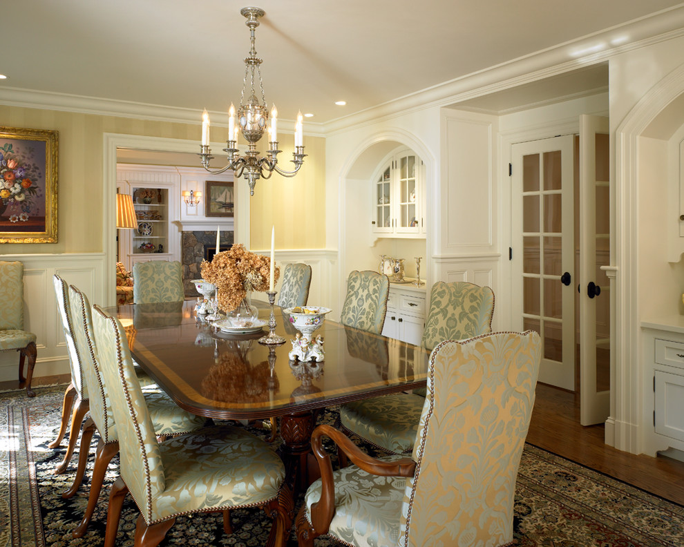 Design ideas for a medium sized classic enclosed dining room in Boston with yellow walls and medium hardwood flooring.