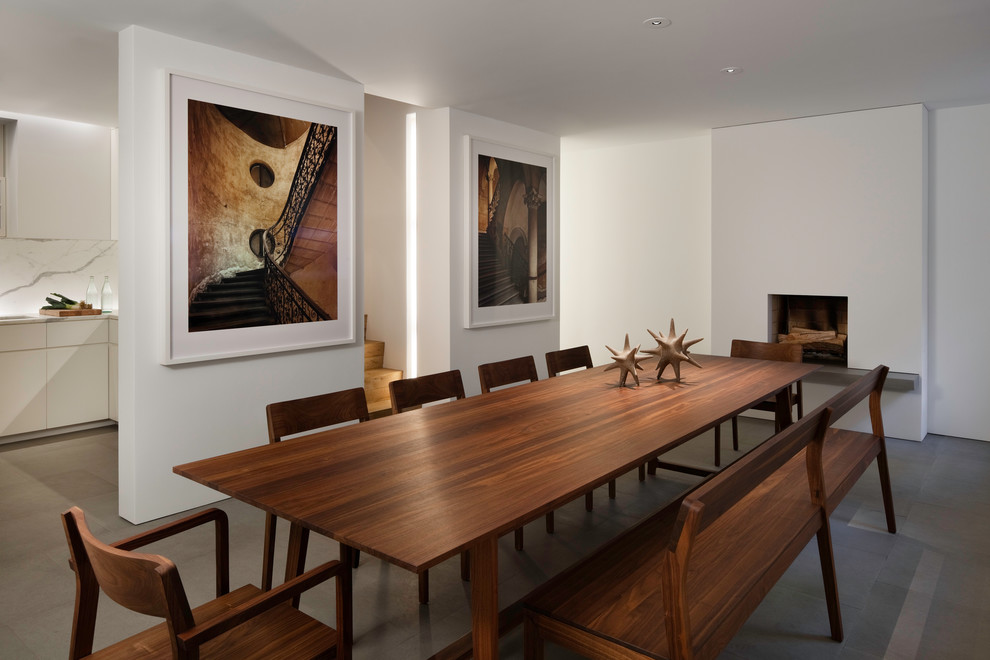 Источник вдохновения для домашнего уюта: столовая в стиле модернизм с белыми стенами, полом из сланца, стандартным камином и серым полом