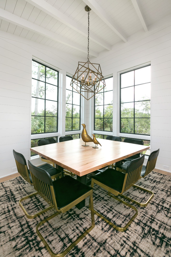 Immagine di una sala da pranzo contemporanea chiusa con pareti bianche, pavimento in legno massello medio e nessun camino