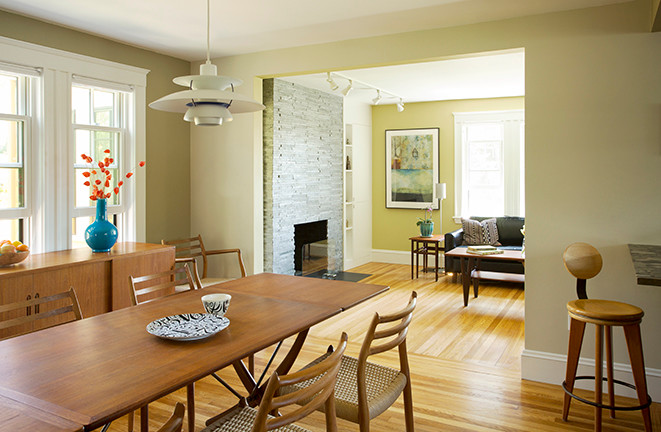 Kleine Retro Wohnküche mit grüner Wandfarbe, braunem Holzboden, Kamin und Kaminumrandung aus Stein in Boston