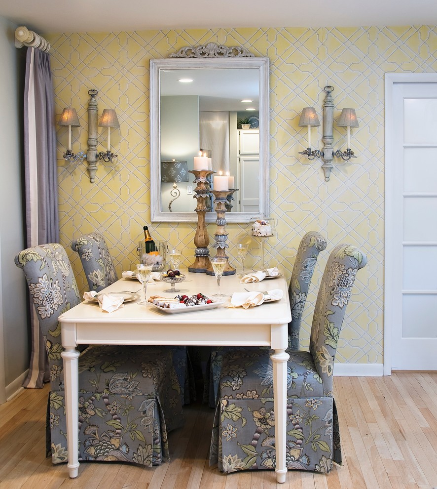 Foto de comedor clásico con paredes amarillas, suelo de madera clara y cortinas