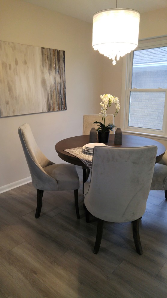 Idee per una piccola sala da pranzo aperta verso il soggiorno minimal con pareti beige, pavimento in laminato e pavimento multicolore