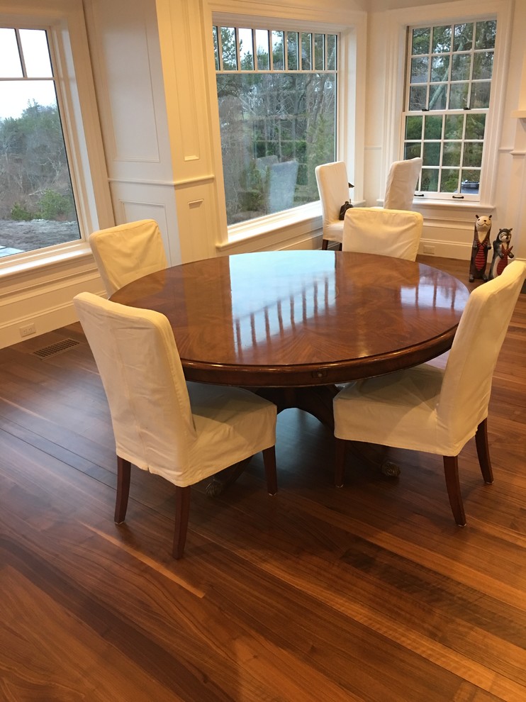 Photo of a medium sized coastal open plan dining room in Boston with white walls, dark hardwood flooring and brown floors.