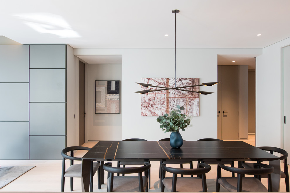 Esempio di una sala da pranzo aperta verso la cucina minimal di medie dimensioni con pareti grigie, parquet chiaro e pavimento beige