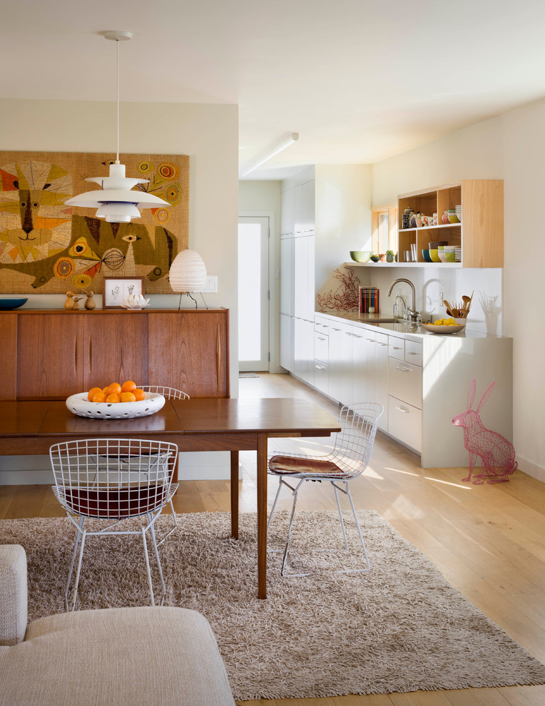 Imagen de comedor contemporáneo pequeño abierto con paredes blancas y suelo de madera clara