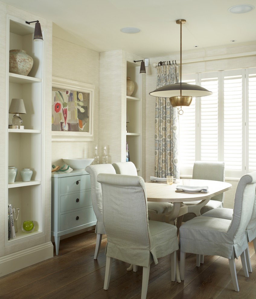 Design ideas for a traditional dining room in London with white walls, medium hardwood flooring and feature lighting.