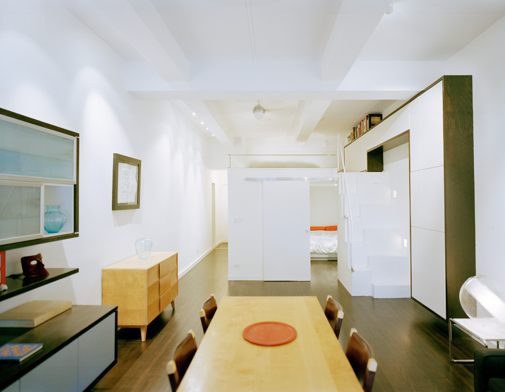 Example of a minimalist dining room design in New York with white walls