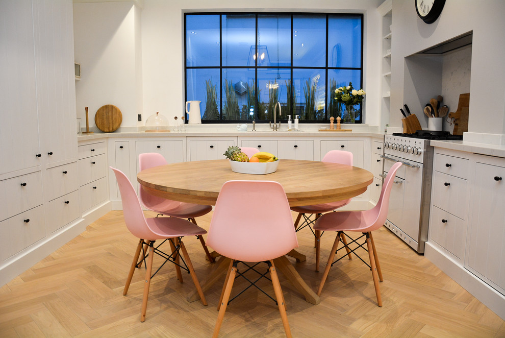 Photo of a medium sized scandi kitchen/dining room in London with light hardwood flooring, white walls and beige floors.