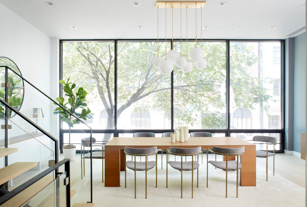 Cette image montre une très grande salle à manger ouverte sur le salon minimaliste avec un mur blanc, parquet clair, aucune cheminée et un sol beige.