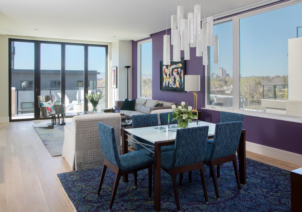 Aménagement d'une salle à manger ouverte sur le salon contemporaine avec un mur violet et parquet clair.