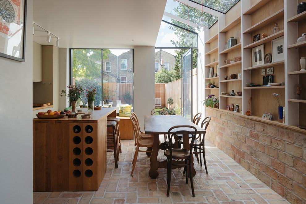 Пример оригинального дизайна: кухня-столовая среднего размера в стиле модернизм с бежевыми стенами, кирпичным полом и оранжевым полом